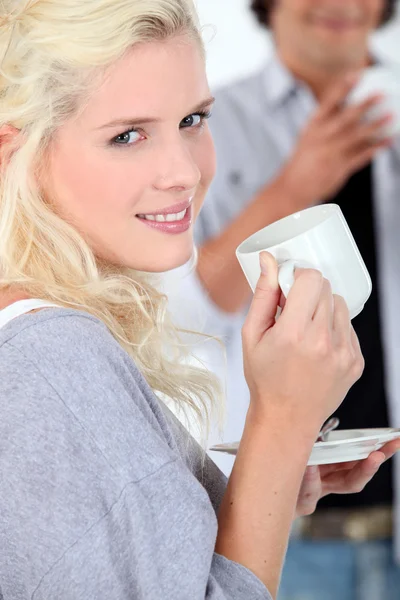 Jonge vrouw met een warme drank te nemen — Stockfoto