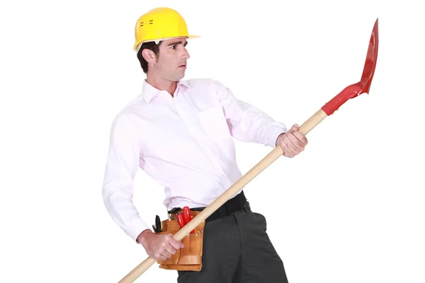 Businessman wearing helmet and holding a shovel Stock Picture