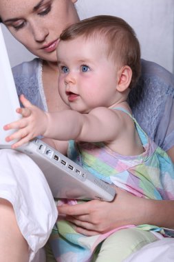 Mother and baby with a laptop clipart