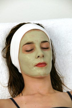 Woman receving facial at day spa clipart