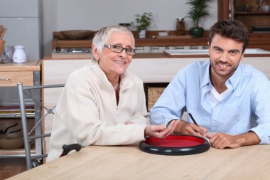 Young man playing with senior woman clipart