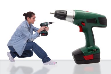 Girl with bun holding drill near giant drill clipart