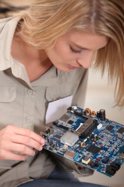 Female computer technician holding circuit board clipart