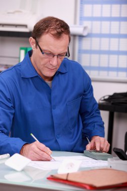 Man using calculator to verify accounts clipart