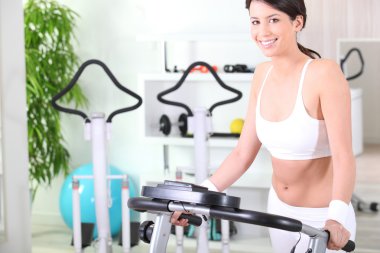 Brunette having exercise in gym clipart