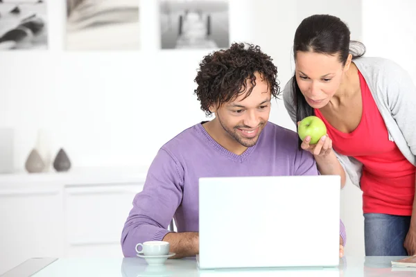 Casal usando um laptop em casa — Fotografia de Stock