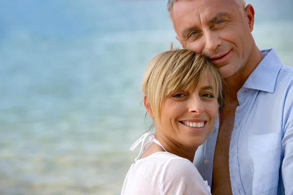 Couple stood hugging on romantic beach — Stock Photo, Image
