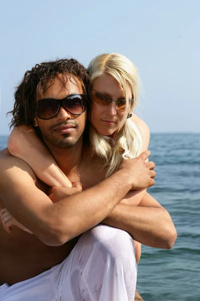 Mixed-race couple hugging at the seaside — Stock Photo, Image