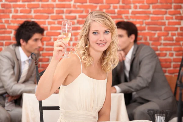 Szőke nő az étteremben pezsgővel — Stock Fotó