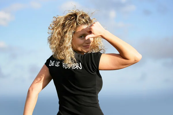 Junge blonde Frau zeigt ihr T-Shirt — Stockfoto