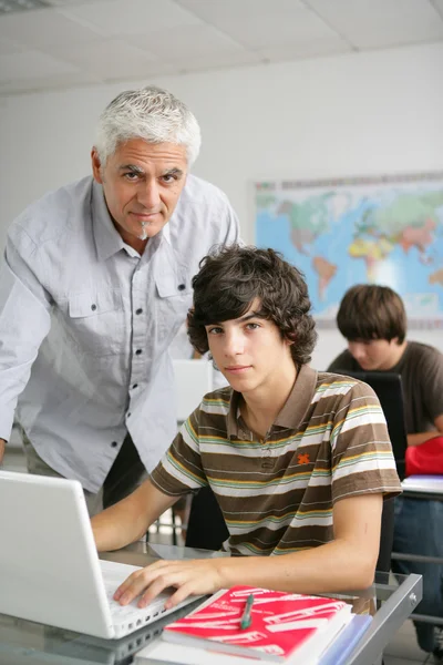 Leraar helpen tiener in klasse — Stockfoto