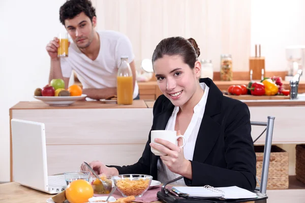 Jovem casal tomando café da manhã juntos na cozinha — Fotografia de Stock