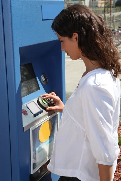 Jovem mulher comprando um bilhete de transporte — Fotografia de Stock