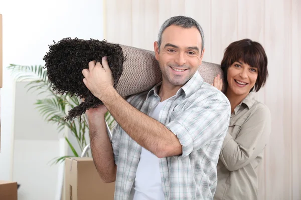 Couple carrying rug — Stock Photo, Image