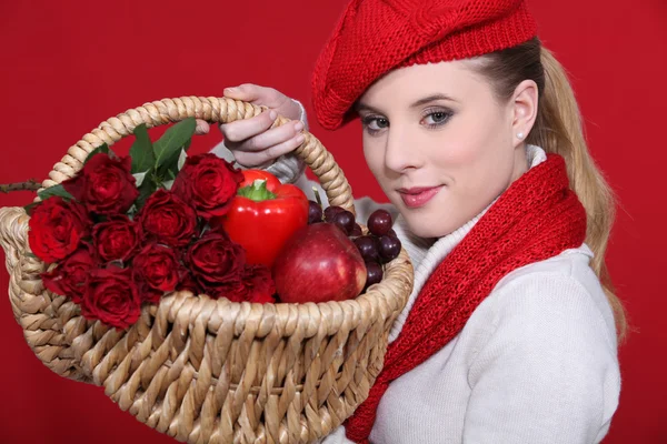 Loira linda carregando cesta cheia de vermelho e vestido para combinar — Fotografia de Stock