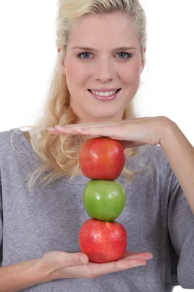 En blond kvinna visar äpplen — Stockfoto