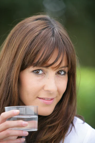 Morena beber copos de água ao ar livre — Fotografia de Stock