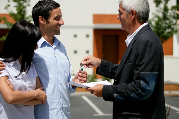 Casal recebendo as chaves de seu novo apartamento — Fotografia de Stock