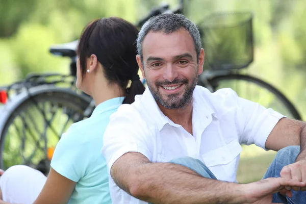 Couple sitting by their bikes in the countryside — Stock Photo, Image
