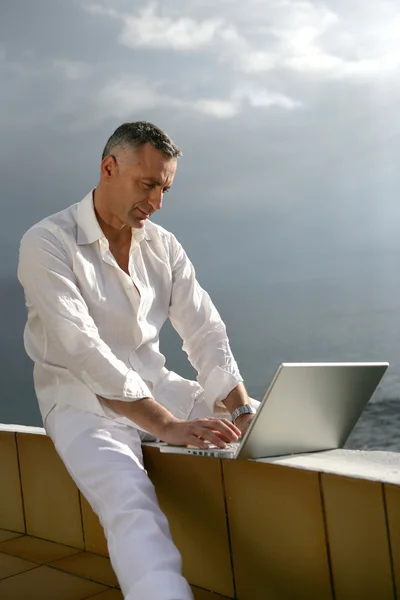 Άνθρωπος που εργάζονται σε φορητό υπολογιστή του από τον ωκεανό — Φωτογραφία Αρχείου