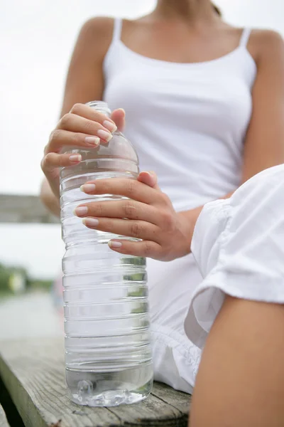 Vrouw die een fles water vasthoudt — Stockfoto