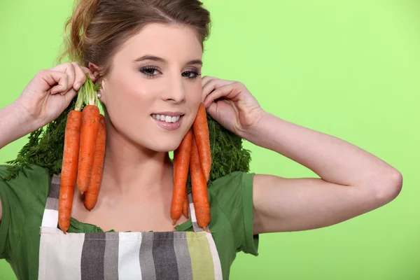 Mulher com cachos de cenouras — Fotografia de Stock