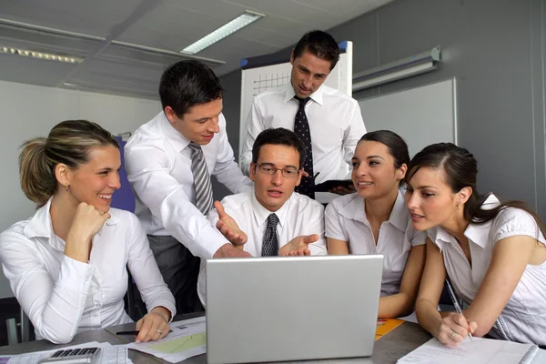 Business team gathered around laptop — Stock Photo, Image