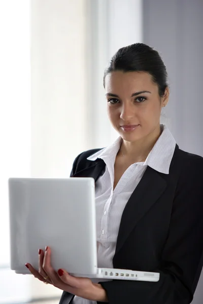 Brunetka interesu posiadania laptopa — Zdjęcie stockowe