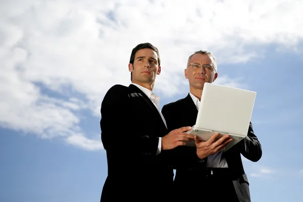 Homens de terno com um computador portátil — Fotografia de Stock