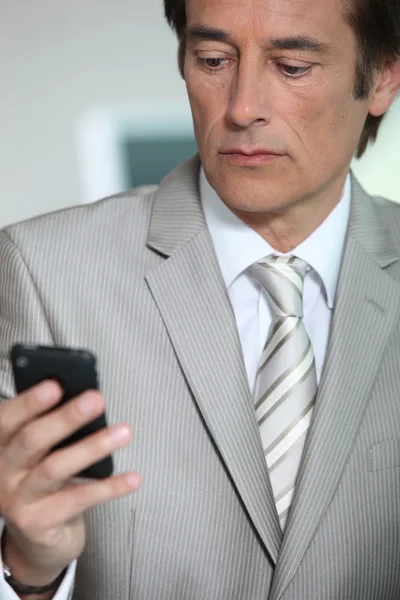 Бизнесмен смотрит в телефон — стоковое фото