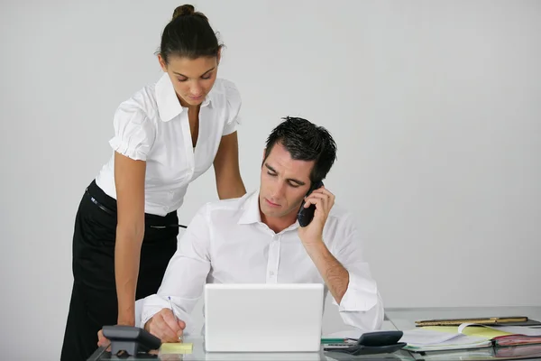 Businessman and his assistant working at the office — Stock Photo, Image