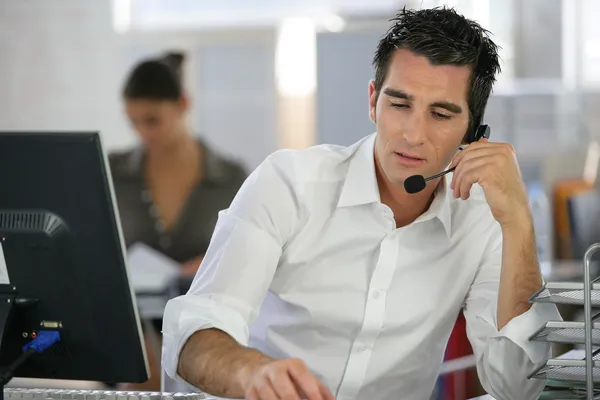 Jonge man telemarketeer in callcenter — Stockfoto