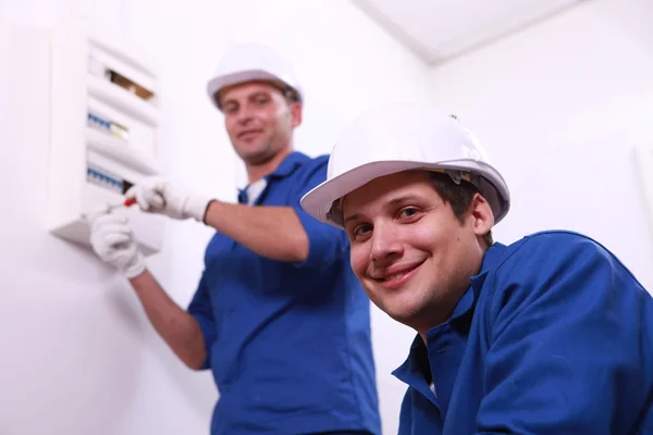 Jonge elektriciens met een fusebox — Stockfoto