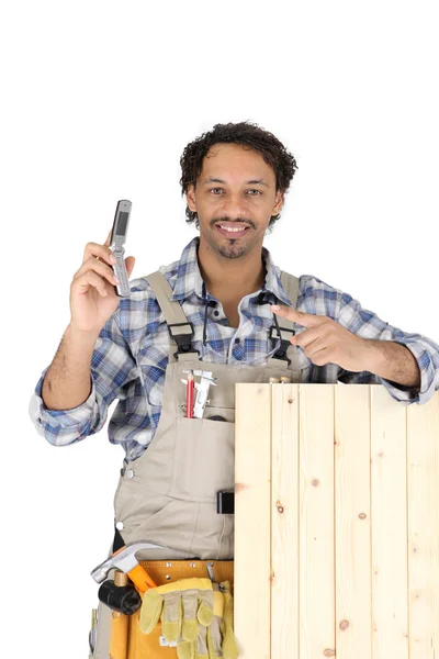 Woodworker segurando um telefone celular — Fotografia de Stock