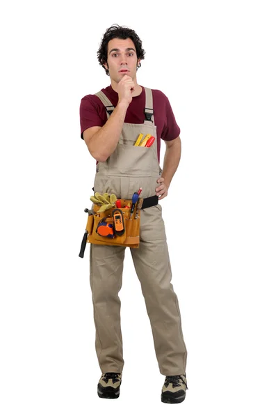 Standing craftsman looks puzzled — Stock Photo, Image