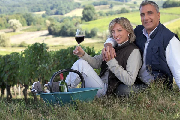 Couple tasting wine in a vineyard — Stok fotoğraf