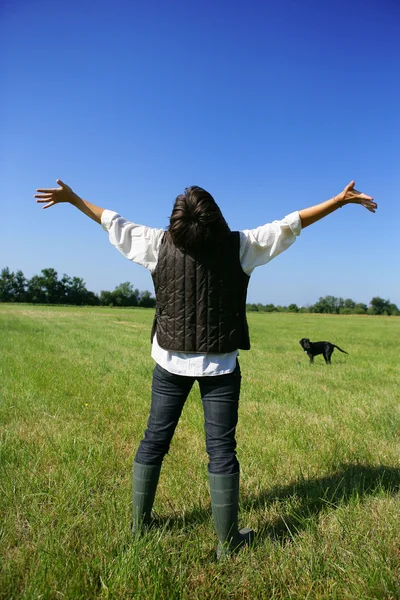 Woman takingher dog foa a walk in open field — Stock Photo, Image