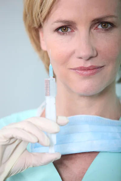 Жіноча медсестра тримає шприц — стокове фото