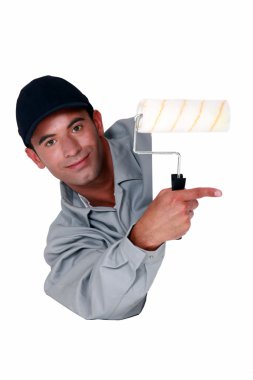 Tradesman holding a paint roller and pointing to a blank sign clipart