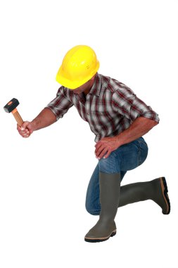 A construction worker with a hammer. clipart