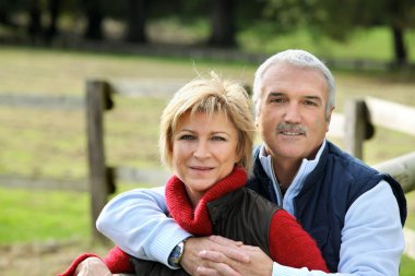 Couple hugging next to fence clipart