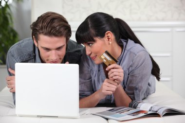 Young man and young woman making online purchases clipart