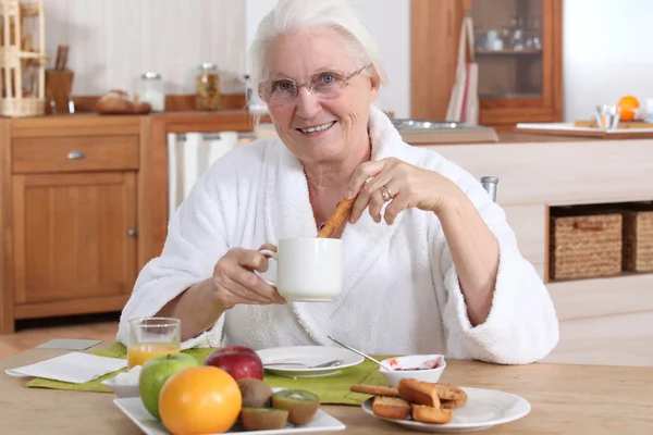 A mature woman having breakfast. — Stock Photo, Image