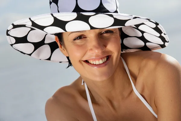 Mulher atraente usando um chapéu elegante na praia — Fotografia de Stock