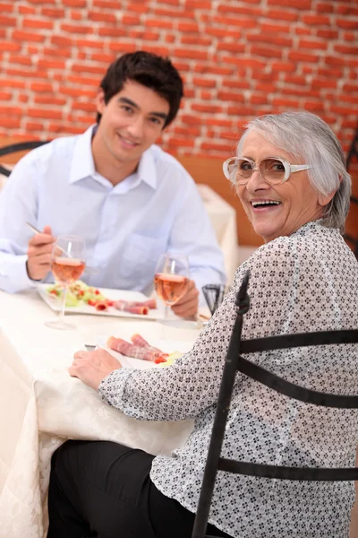 Mulher desfrutando de uma refeição com seu neto — Fotografia de Stock