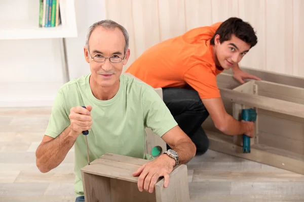 Padre e hijo ensamblando muebles — Foto de Stock