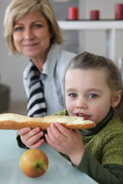 Kleines Mädchen isst Toast mit Brot — Stockfoto