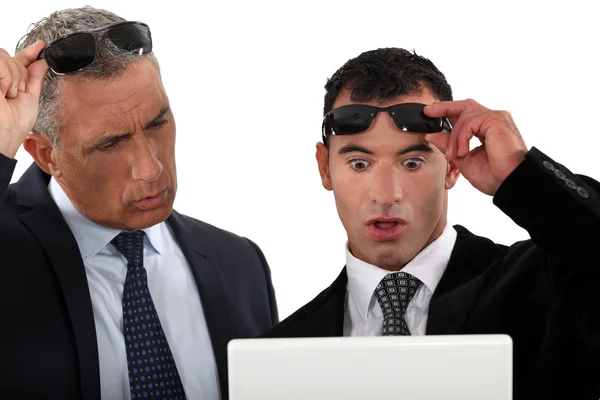 Deux hommes d'affaires regardant leur ordinateur portable très surpris — Photo