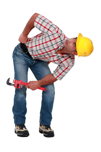 A plumber looking underneath something. — Stock Photo, Image