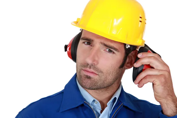Homem usando protetores auriculares de segurança e capacete — Fotografia de Stock